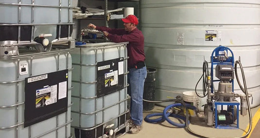 Man Standing Near Bulk Storage Totes